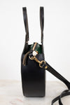 Black handbag with gold zipper on a white background