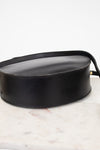 Bottom of black leather handbag on a marble surface