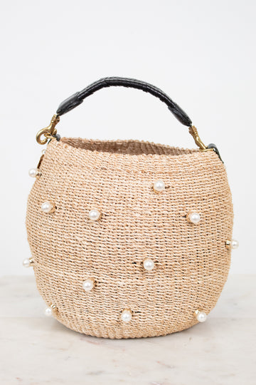 Woven handbag with pearl embellishments on a light background