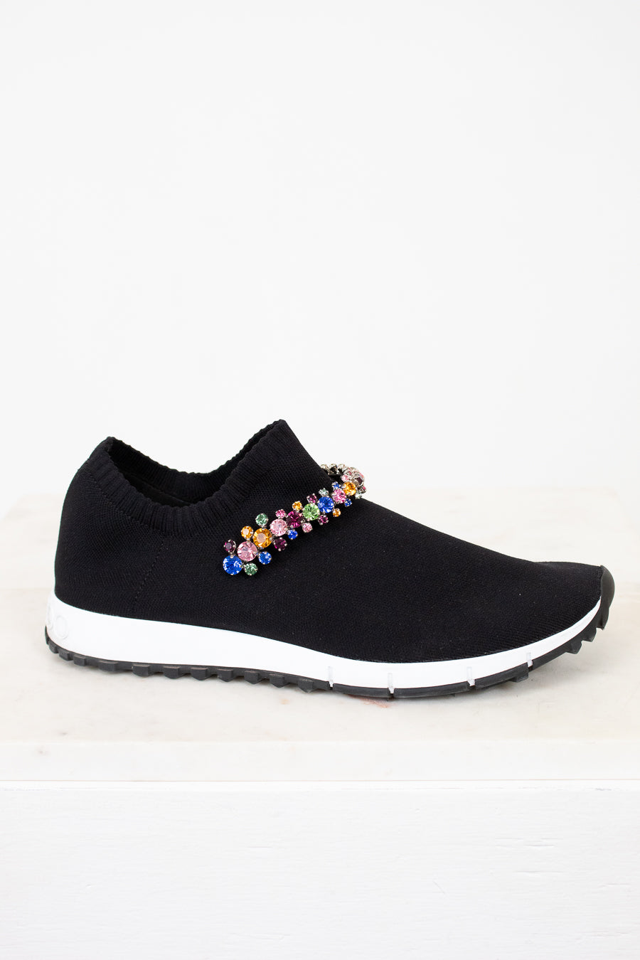 Black slip-on sneaker with colorful embellishments on a white background