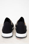 Black sneakers with embellishments on a white background