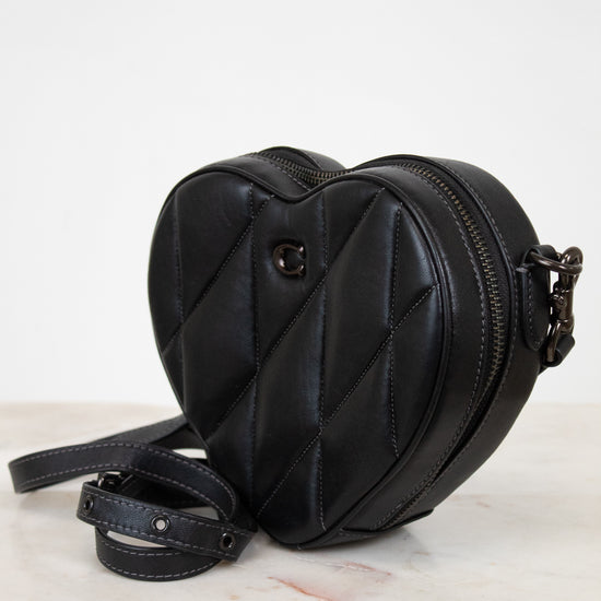 Black heart-shaped bag on a light gray background