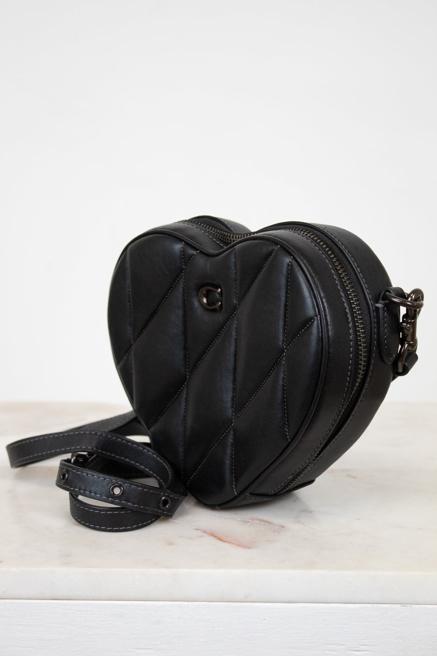 Black heart-shaped bag on a light gray background