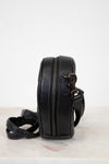 Black leather crossbody bag with a strap on a white surface