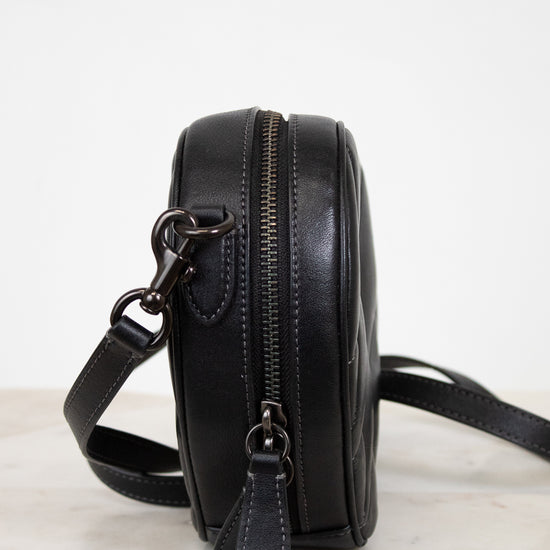 Black leather crossbody bag on a light background
