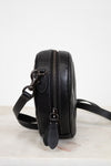 Black leather crossbody bag on a light background