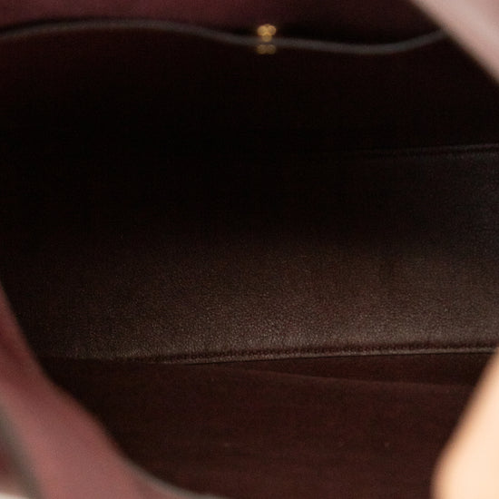 Close-up of a maroon leather handbags interior with a gold clasp.