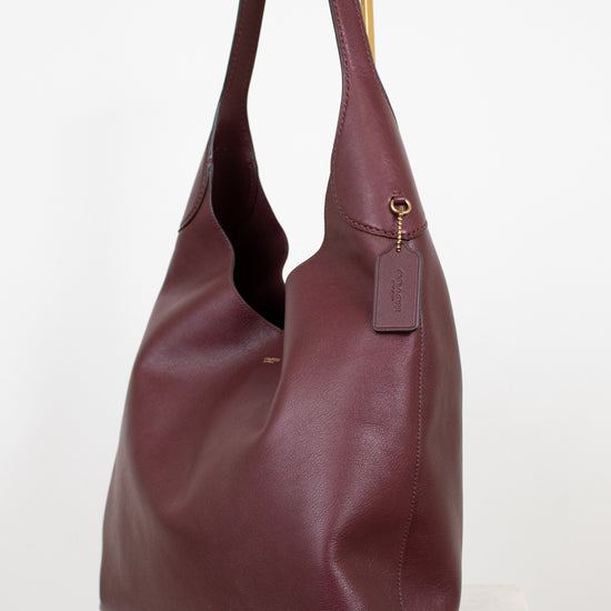 Maroon leather handbag on a white background