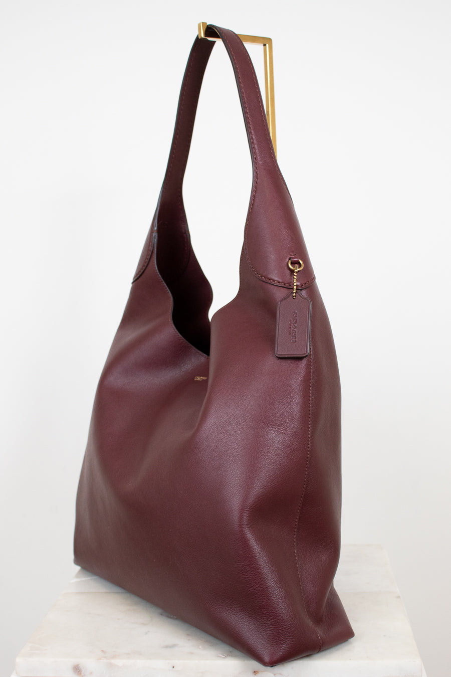 Maroon leather handbag on a white background