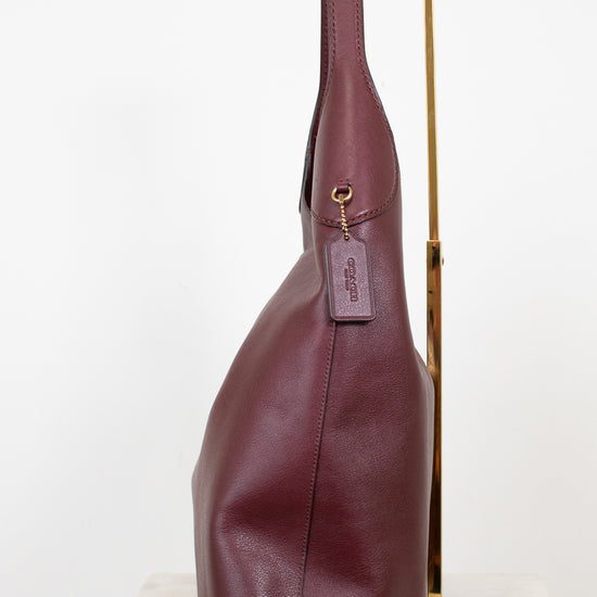 Purple leather handbag with a visible brand logo on a white background