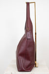 Purple leather handbag with a visible brand logo on a white background