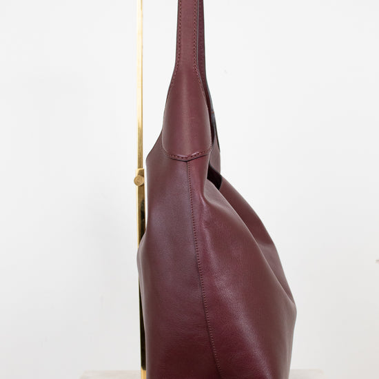 Maroon leather handbag on a white background
