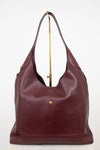 Maroon leather handbag with gold accents on a white background