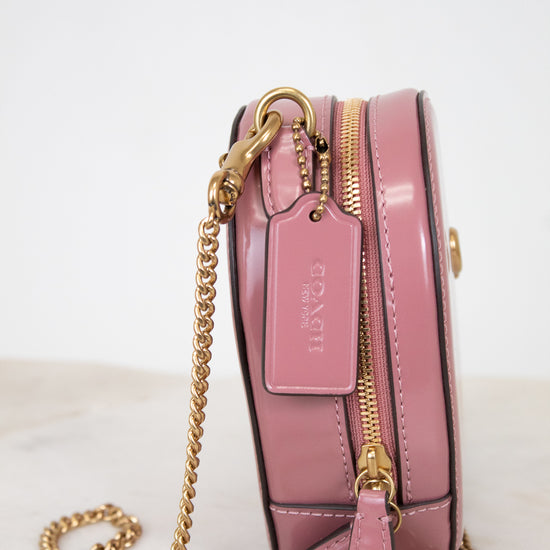 Pink handbag with gold chain on a light background
