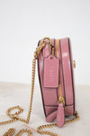Pink handbag with gold chain on a light background