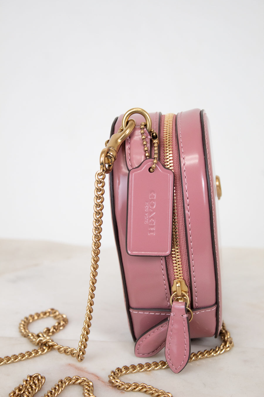 Pink handbag with gold chain on a light background