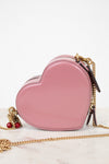 Pink heart-shaped handbag with gold chain on a white background