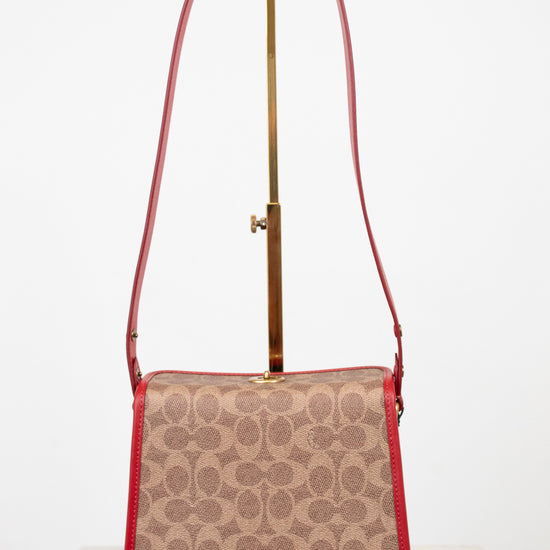 Patterned handbag with a red strap on a white background