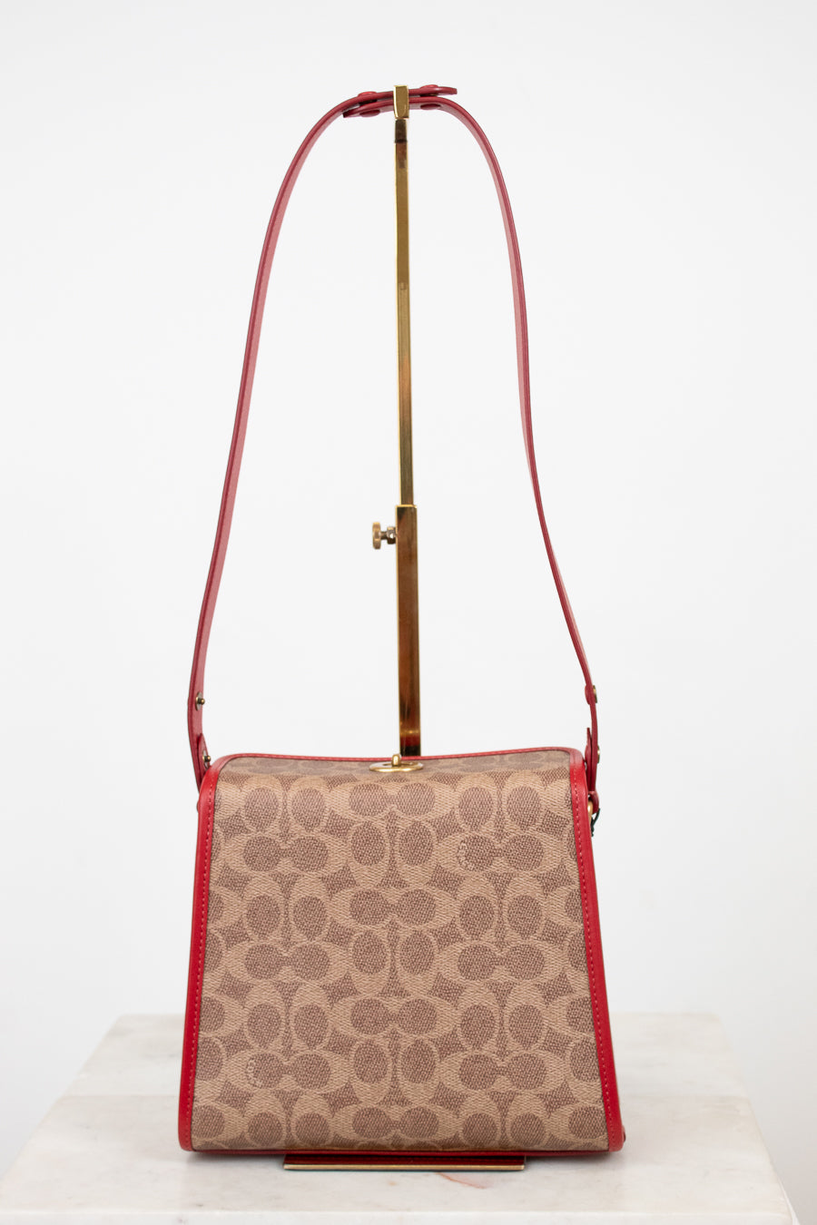 Patterned handbag with a red strap on a white background