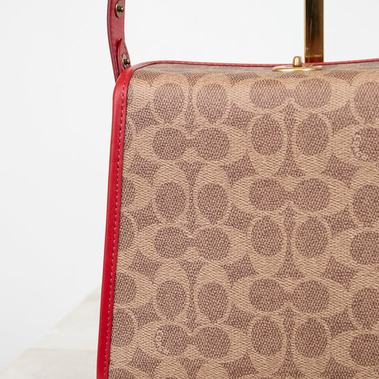 Coach handbag with red accents on a white background