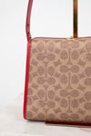 Coach handbag with red accents on a white background