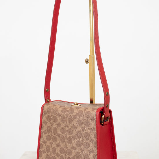 Handbag with red strap and beige pattern on a white background
