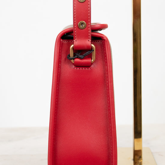 Red handbag with a gold strap on a white background