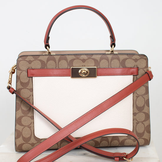 Coach handbag with brown pattern and red accents on a white background