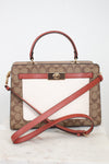 Coach handbag with brown pattern and red accents on a white background