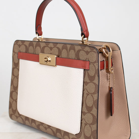 Designer handbag with brown and red accents on a light background
