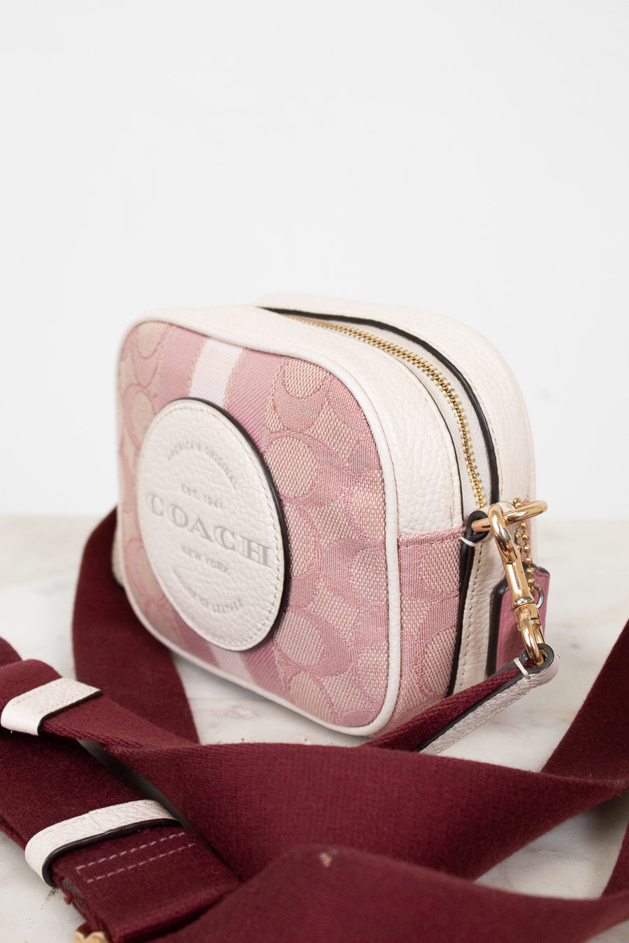 Coach handbag with pink and white pattern on a white background
