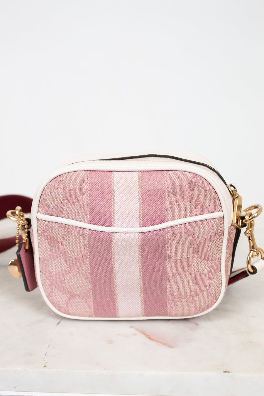 Pink and white striped handbag on a light background