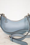 Light blue handbag with a matching strap on a light background