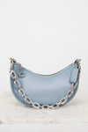 Light blue handbag with silver chain detail on a white background