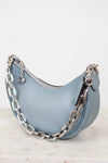Light blue handbag with a silver chain on a white background