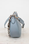 Light blue handbag with a chain detail on a white background