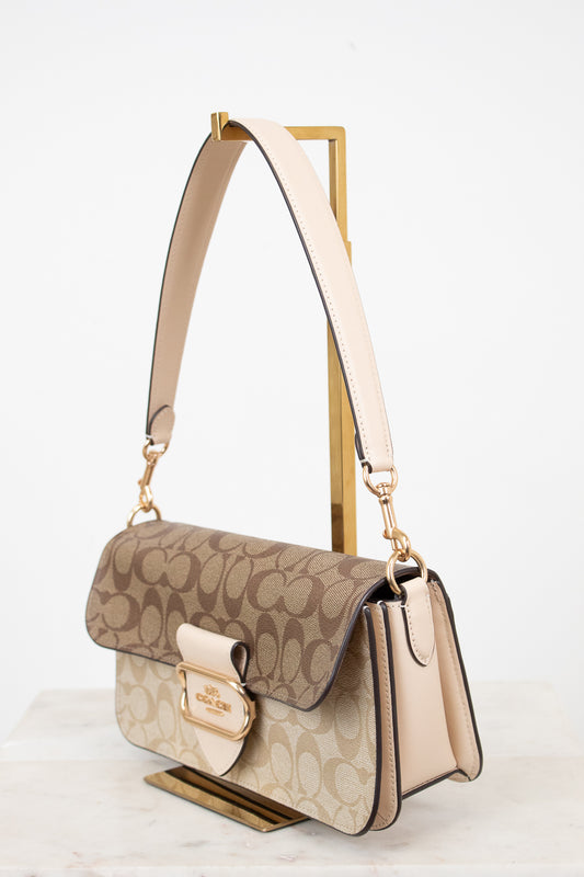 Beige and brown handbag with gold accents on a white background