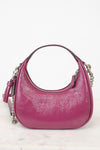 A pink pebbled leather hobo handbag with silver chain strap details, displayed on a light marble surface against a white background.