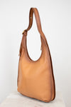 Tan leather handbag on a white background