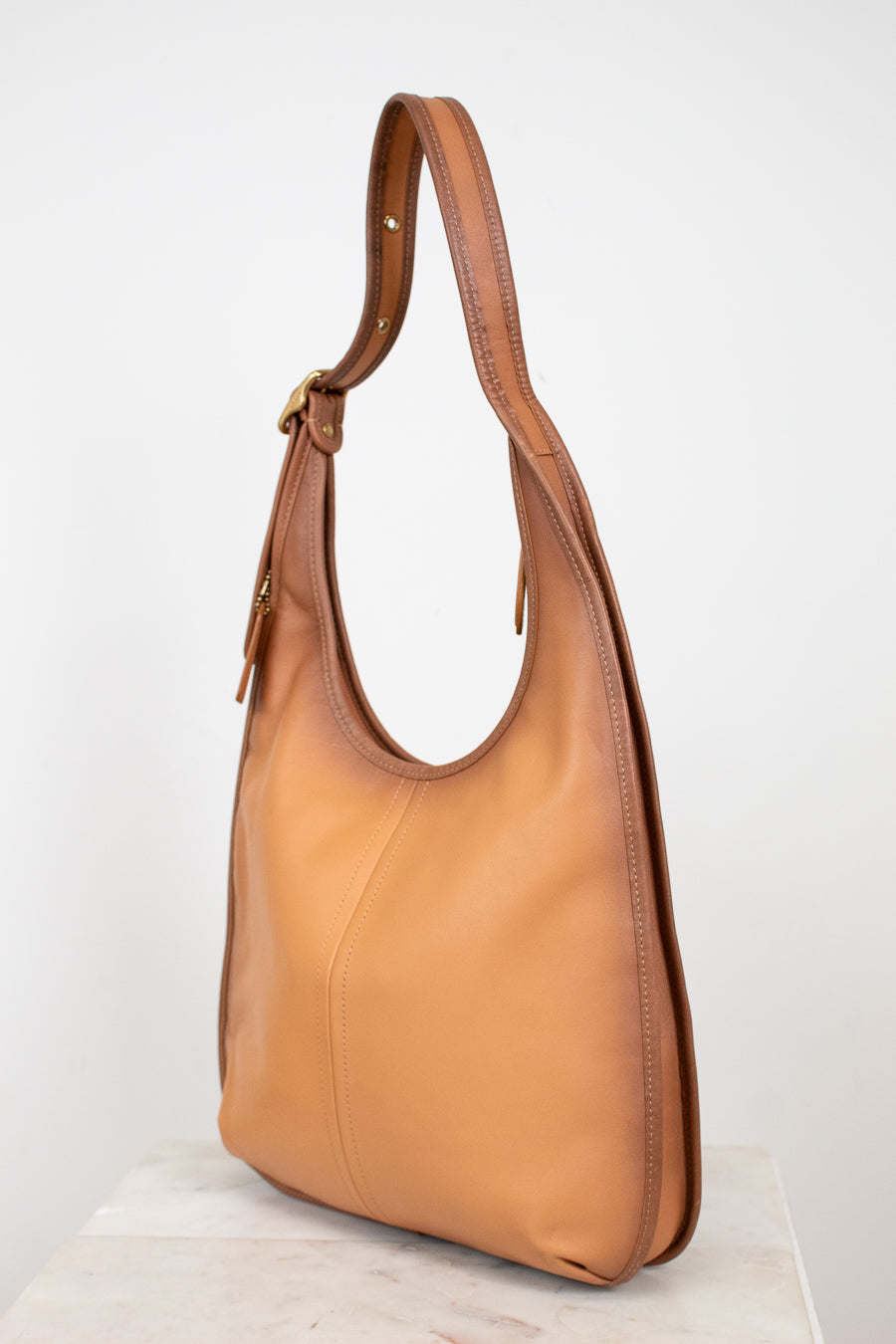 Tan leather handbag on a white background