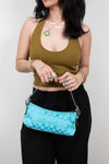 Woman holding a turquoise handbag with a white background
