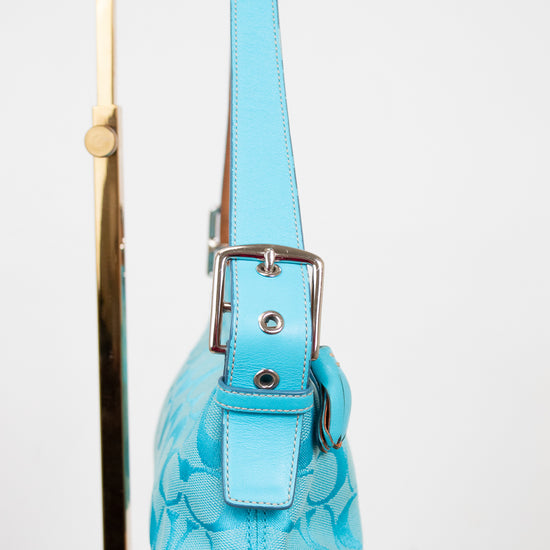 Blue handbag with a matching strap on a white background