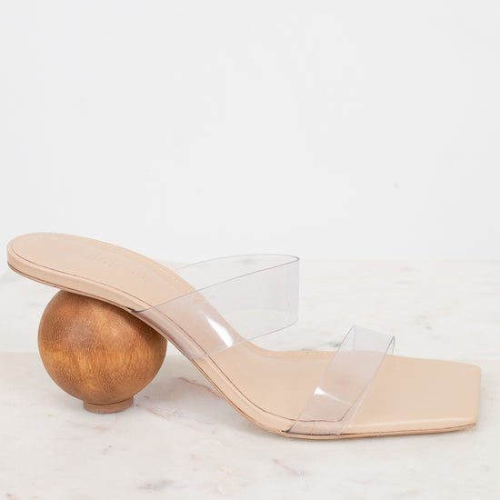 Beige sandal with transparent strap and wooden ball heel on a white background