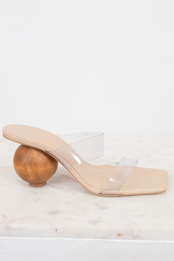 Beige sandal with transparent strap and wooden ball heel on a white background