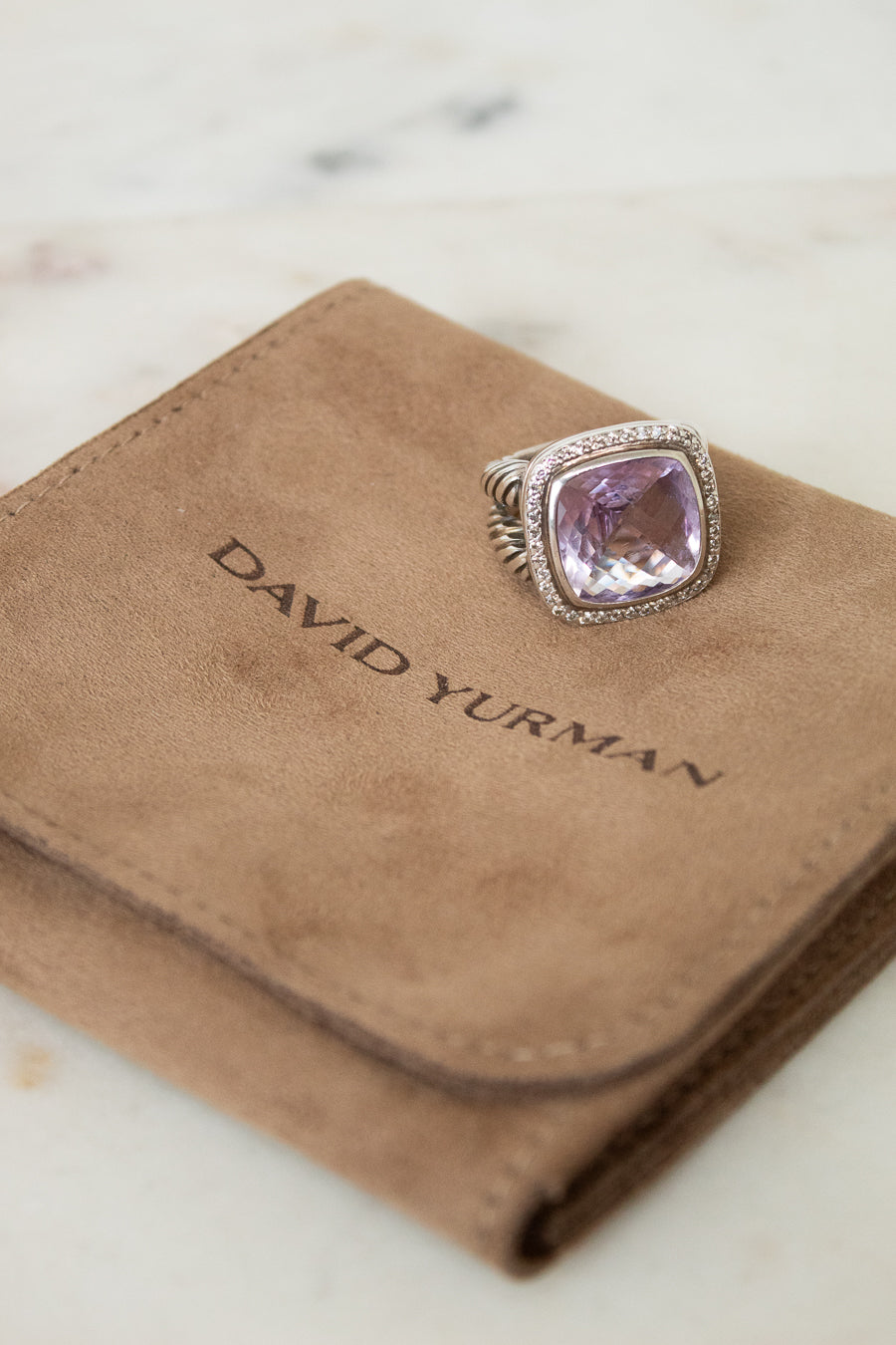 David Yurman ring with purple stone on a brown velvet dustbag