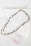 Necklace with small pearls on a white marble surface