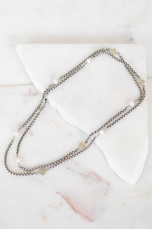 Necklace with small pearls on a white marble surface