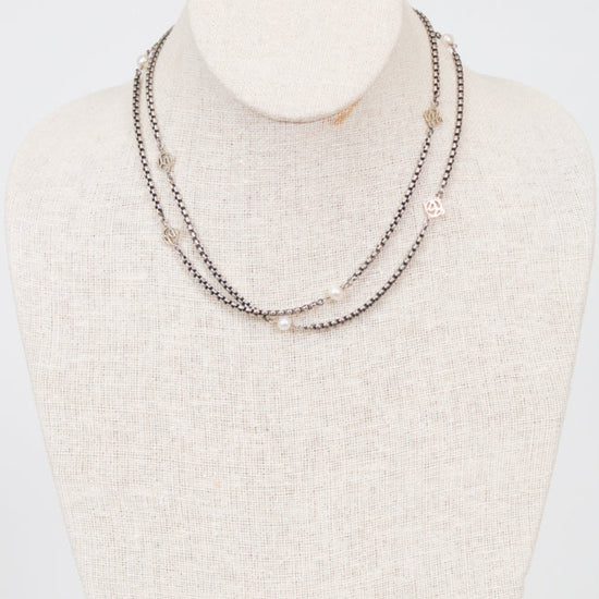 Necklace displayed on a mannequin bust against a white background