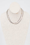 Necklace displayed on a mannequin bust against a white background