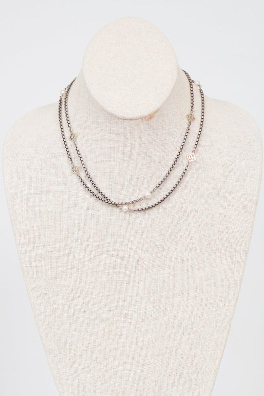 Necklace displayed on a mannequin bust against a white background